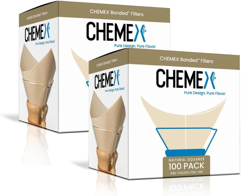 Unbleached cone paper coffee filters resting in a glass pour-over coffee maker